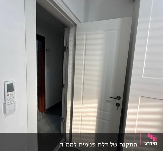 דלת לבנה פתוחה עם ידית כסופה